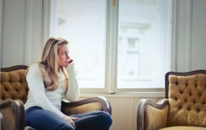 woman sitting on a chair looking out of the window